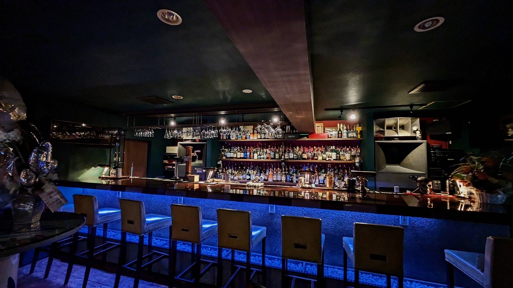 木のテーブル席とカウンター席がゆるやかにつながる店内全景