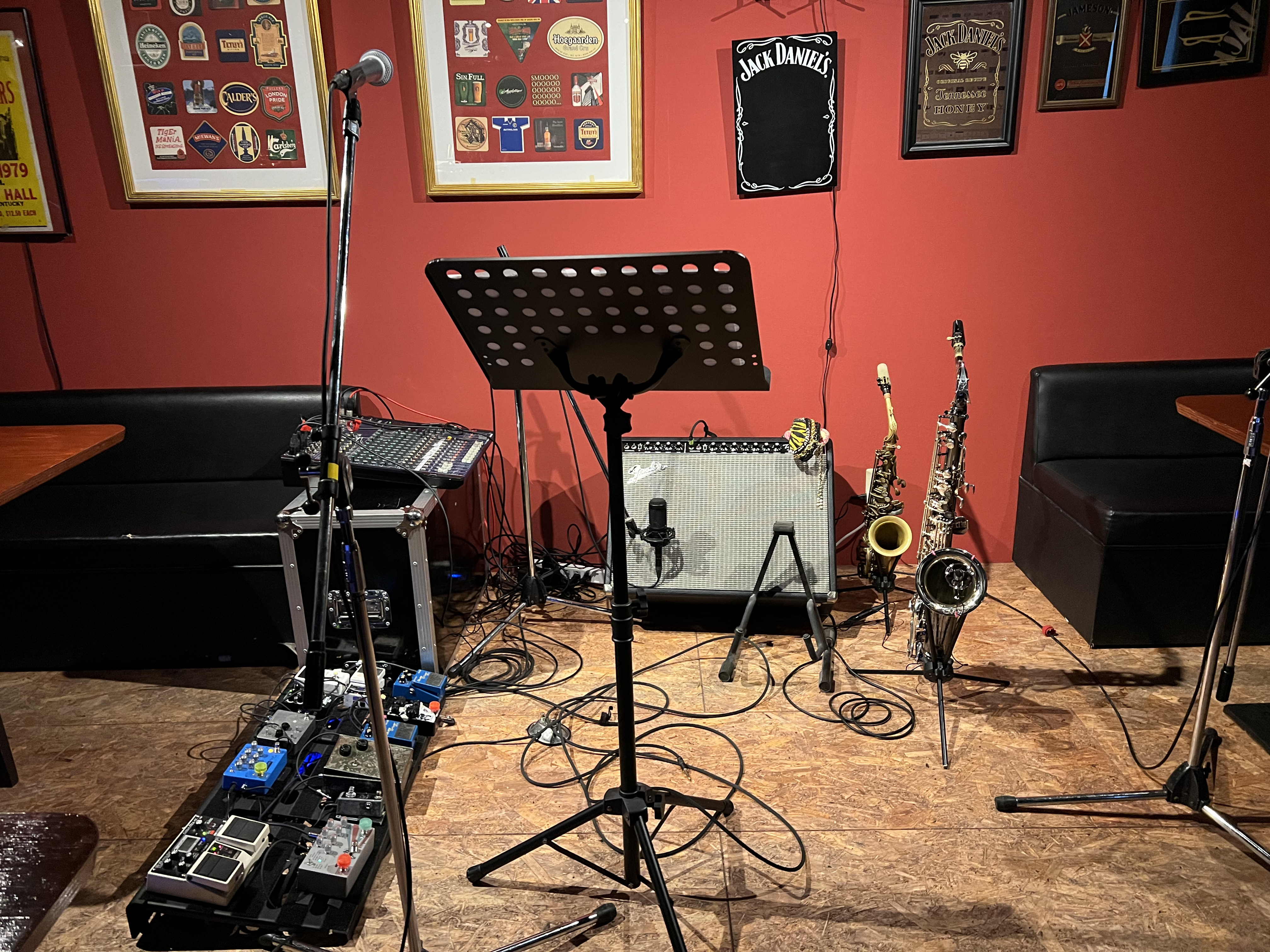 An interior where guests sip drinks while listening to jazz in front of a small stage