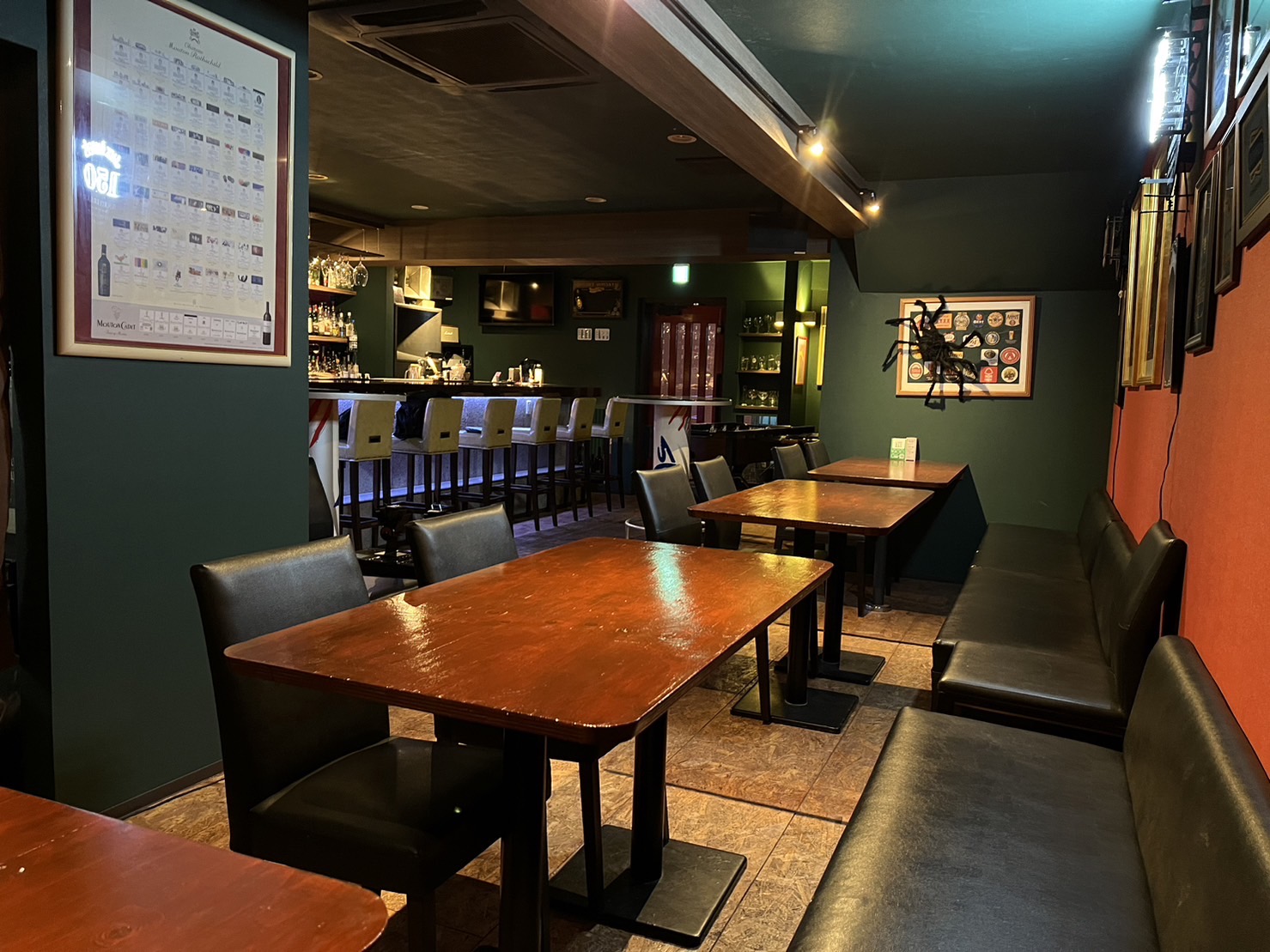 Guests making small talk around a high table, with wall-mounted bracket lights along the wall