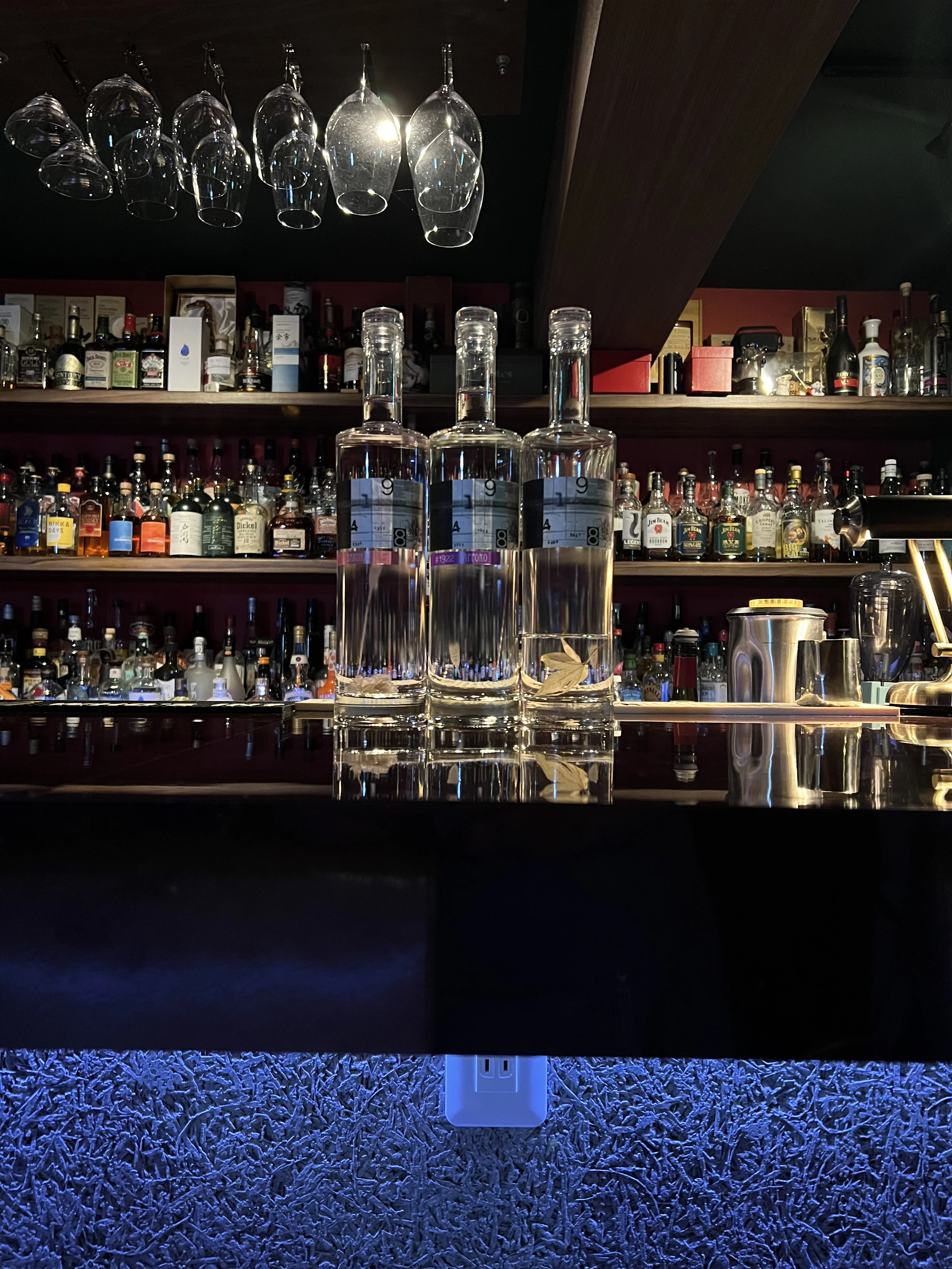 木のテーブル席とカウンター席のあいだをやわらかな灯りがつなぐ夜の店内